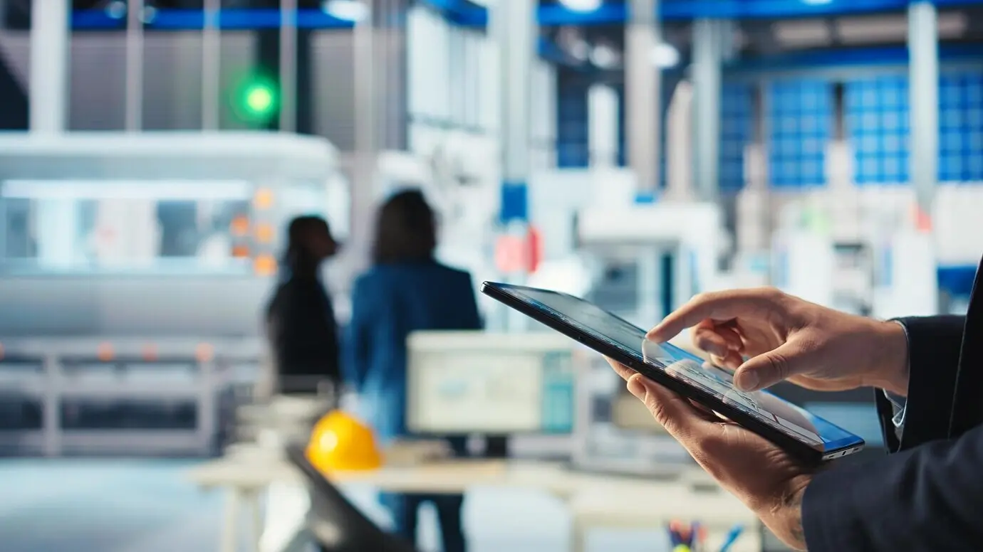 Сотрудник фотовольтаического завода использует на планшете программное обеспечение для отслеживания, чтобы диагностировать систему.